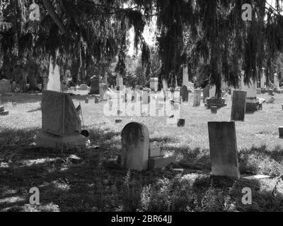 Uralter Friedhof in Schwarz und Weiß aus dem 19. Jahrhundert. Einige Steine sind kurz davor, zu fallen, und zeigen Vernachlässigung und Verschleiß. Stockfoto