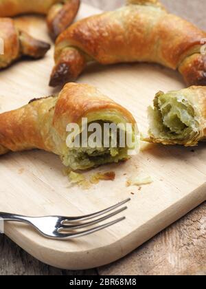 Leckere Croissants mit Matcha auf einem Schneidebrett, gesundes Frühstück Konzept Stockfoto