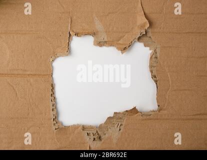Runde gerissene Loch in braunem Papier, weißer Hintergrund, Nahaufnahme Stockfoto