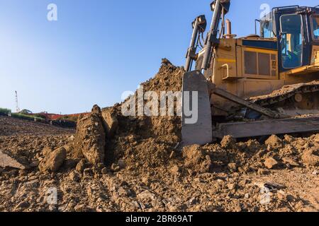 Bau Industrie Erdbau Deponie Dozer Maschine Schaufel Eimer Sand Steinen Closeup abstrakt bewegen. Stockfoto