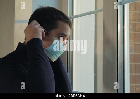 Der Mensch geht in einer medizinischen Maske spazieren Stockfoto