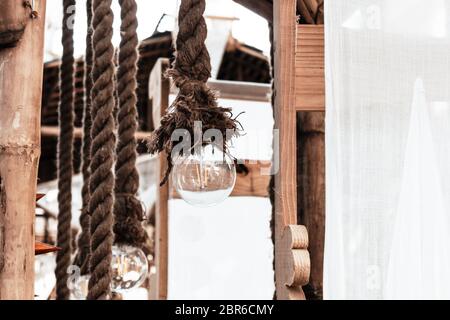 Hängende Girlanden elektrische Glühbirne, Seil auf dem Dach einer Terrasse am Meer oder Veranda des Restaurants gebunden. Weit verbreitet für die Dekoration von diwali, chri Stockfoto