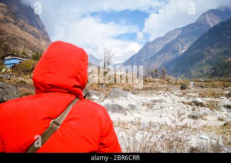 Active Senior nepalesischen schöne Frau in Rot winter Jacke mit Blick auf die Berge und blauer Himmel. Entspannende Momente warten auf den Sonnenuntergang. Genießen Stockfoto