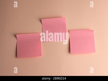 Drei rosa Papier Aufkleber auf Pfirsich Hintergrund eingefügt, in der Nähe Stockfoto