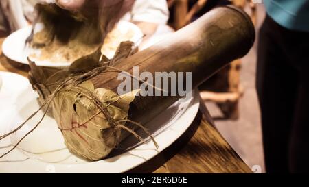 Ein traditionelles Bambus Chicken Biryani von Tribal Dorf von Indien. Reis und Huhn gemischt in Gewürzen in ein Stück Rohstoff Bambus gefüllt anmelden, dass o geht Stockfoto