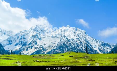 Breites Panorama der schneebedeckten Gipfel und blauen Himmel mit Wolken in Baisaran Tal (Mini Schweiz), Pahalgam, Kaschmir, Indien Stockfoto