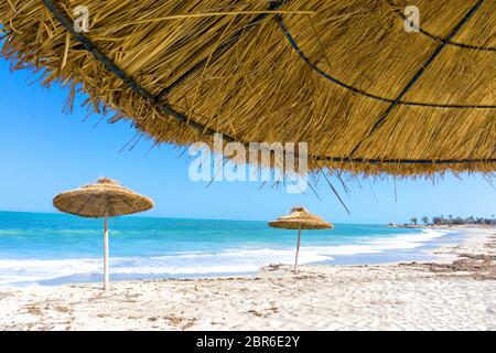 Landschaft der Sonnenschirme am Strand von Djerba in Tunesien Stockfoto