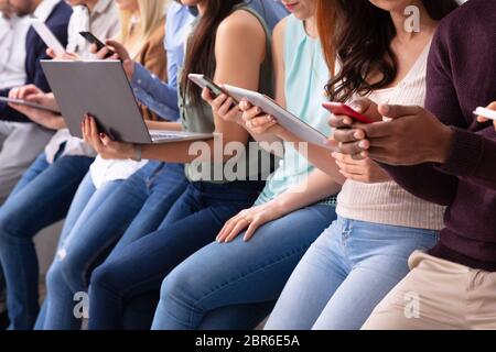 Multirassischen tausendjährigen Menschen in Zeile beschäftigt sich mit modernen elektronischen Gadgets Stockfoto