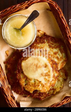 Frische, hausgemachte Reibekuchen oder Pfannkuchen mit Apfelmus im Korb, einem traditionellen deutschen Snack oder Gericht namens Kartoffelpuffer oder Reibekuchen, Foto Stockfoto