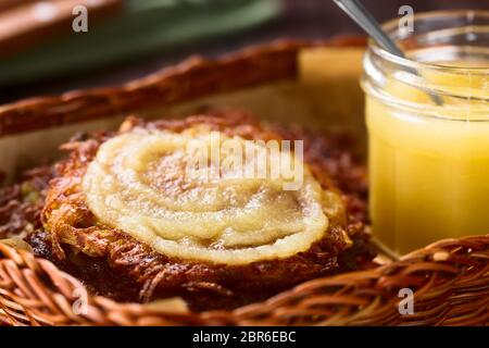 Frische hausgemachte thin Reibekuchen oder Pfannkuchen mit Apfelmus im Korb, einem traditionellen deutschen Snack oder Gericht namens Kartoffelpuffer oder Reibekuchen ( Stockfoto