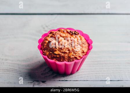 Gekochte Haferflocken Muffin in einem rosa Silikon Backformen über hellen Hintergrund. Stockfoto