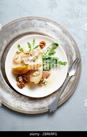 Birnensalat mit Walnüssen, Prosciutto, Rucola und Blauschimmelkäse. Abendessen Vorspeise Stockfoto