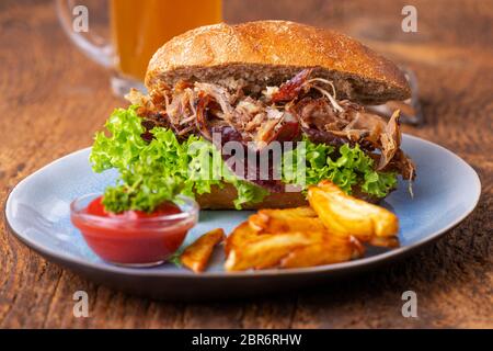 Gezogen von Schweinefleisch in einem Brötchen mit Bier Stockfoto