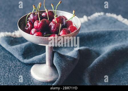 Frische Kirschen in Vintage silver Vase auf dem dunklen Hintergrund Stockfoto