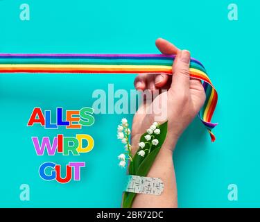 Text 'alles wird gut' bedeutet auf Deutsch 'alles wird gut'. Regenbogenband mit Handgriff. Band-Aid mit Blumen. Symbole der öffentlichen Unterstützung Stockfoto