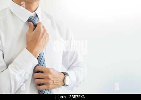 Mode und Kleidung Konzept - bis Geschäftsschluss Mann im Hemd Dressing up und Einstellung der Riegel am Hals Stockfoto