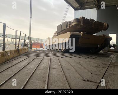 Ein M1A2 Abrams-Panzer mit der 401. Armee-Feldunterstützungsbrigade wird an Bord der USNS Brittin geladen, als Teil einer normalen Rotation von Ausrüstung aus dem Einsatzgebiet des Zentralkommandos (CENTCOM) im Hafen von Shuaiba, Kuwait, 9. Mai 2020. Das Bob Hope-Klasse Roll on Roll off Schiff transportiert Ausrüstung von der 401st AFSB, 7th Transportation Brigade (Expeditionary) und I Marine Expeditionary Force. (USA Armeefoto von Sgt. Lazaro A. Reyes) Stockfoto