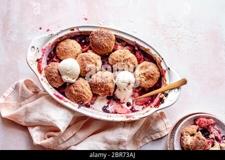 Cranberry Apfel Schuster in einer Backform mit Kugeln Eis. Stockfoto