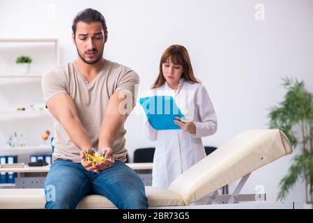 Männlicher Diabetiker, der einen jungen Arzt besucht Stockfoto