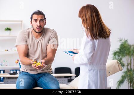 Männlicher Diabetiker, der einen jungen Arzt besucht Stockfoto