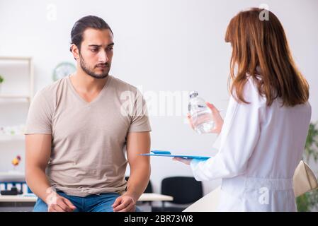 Männlicher Diabetiker, der einen jungen Arzt besucht Stockfoto