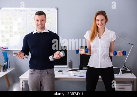 Nahaufnahme der männlichen und weiblichen Unternehmer Trainieren in Office mit Hanteln Stockfoto