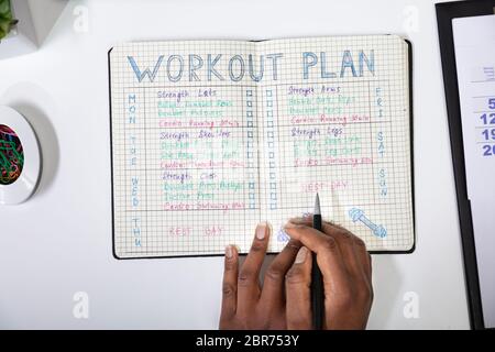 Einen erhöhten Blick auf eine Person, die Kenntnis von Workout Plan auf Notebook Stockfoto