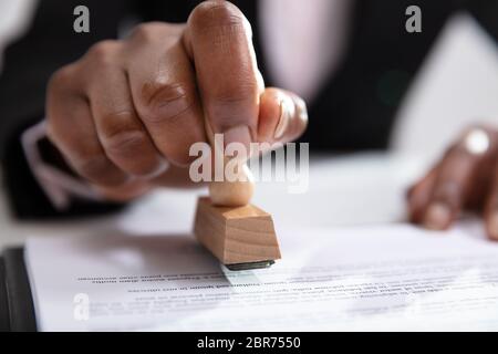 Nahaufnahme der Geschäftsfrau Stempel setzen auf Dokumente im Büro Stockfoto