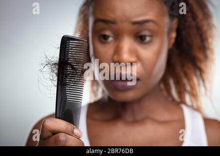 Nahaufnahme von einem besorgten Frau mit Kamm leiden unter Haarausfall Stockfoto