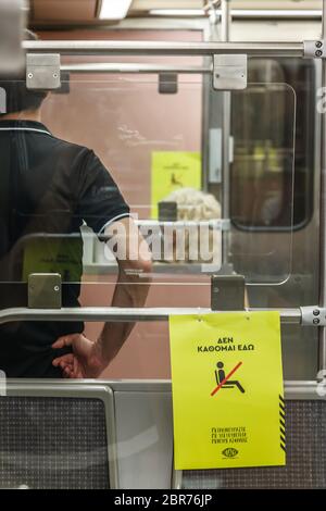 "Ich sitze nicht hier", heißt es in der rcard auf der Hälfte der Sitze in den Athener Metro-Wagen, die Passagiere anweist, wegen des Coronavirus-Ausbruchs Entfernungen zu halten Stockfoto