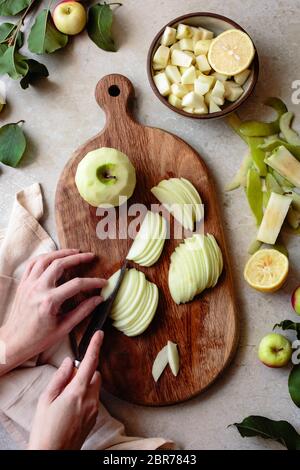 Handmesser zum Schneiden von Äpfeln auf einem Holzbrett. Stockfoto