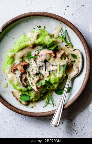 Grüner Kartoffelpüree mit Pilzsoße. Stockfoto