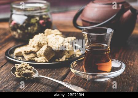 Schwarzer Tee in armudu Glas und Löffel Sonnenblumenöl halva Stockfoto