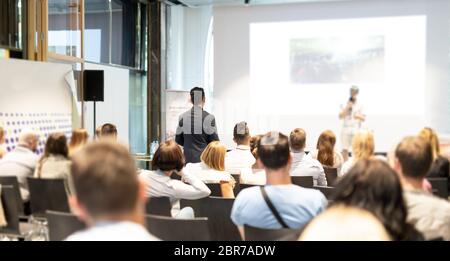 Ich habe eine Frage. Gruppe von Geschäftsleuten in Konferenzsaal. Unternehmer im Publikum stehen und Fragen stellen zu speeker. Konferenz und Präsentation Stockfoto