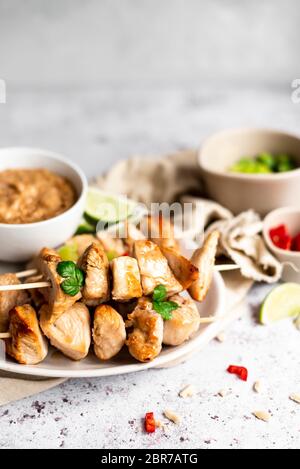 Hähnchenspieße Mit Satay-Sauce Und Frühlingszwiebeln Und Chili-Pfeffer-Seiten Stockfoto