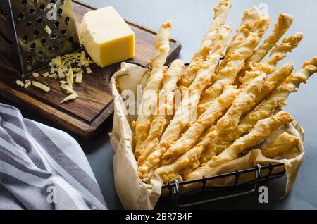 Käse stick. Grissini mit Käse auf dunklem Hintergrund, Konzept für Snack oder Party Time Stockfoto