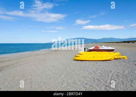 Tretboote und Kajaks auf eine Kies Strand am Tyrrhenischen Meer in Kalabrien, Italien Stockfoto