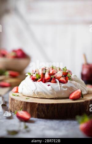 Pavlova Kuchen mit Erdbeeren auf dem Tisch. Vorderansicht Stockfoto