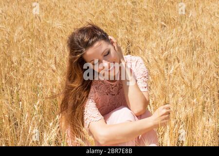 Schöne Teenage Model Mädchen auf dem Feld in Sun Light liegen. Spätsommer. Schönheit Romantische Mädchen Im Freien. Sonne, Sonnenschein. Hintergrundbeleuchtung. Durchgetönt Stockfoto