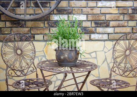 Schöner Platz im Garten im mediterranen Stil, Topf mit Lavendel auf dem Tisch Stockfoto