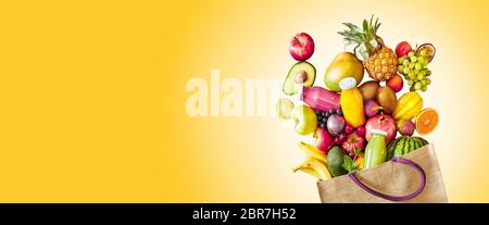 Bunte gelb panorama Banner mit Kopie Raum ein großes Sortiment an frischen tropischen Früchten und Säften, die reich an Vitaminen Verschütten von einem wiederverwendbaren gro Stockfoto