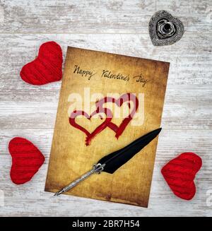 Antike Vorlösung mit handgeschriebener Happy Valentines Day, 3 rote Kuschelherz, rot bemalte Herzen, detailreiche silberne Kiel-Ständer in Form von hart, ornam Stockfoto
