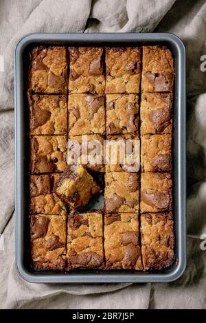 Trend Backen Brookies Schokolade Brownies und Cookies hausgemachte Kuchen durch Quadrate in Backblech auf grauem Leinentuch Hintergrund geschnitten. Flach, Platz Stockfoto