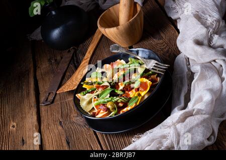 Nudelsalat mit grünem Spargel, Oliven und Parmaschinken Stockfoto