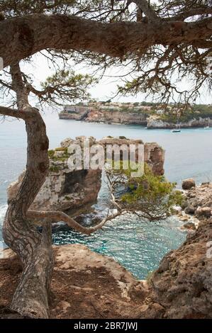 Es Pontas auf Mallorca mit Boot in der Nähe im Mittelmeer verankert. Mallorca Sonnenaufgang mit Yacht und Felsbogen bei Santanyi. Mallorca Cala Llombar Stockfoto