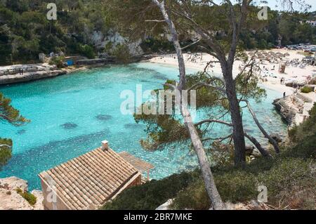 Es Pontas auf Mallorca mit Boot in der Nähe im Mittelmeer verankert. Mallorca Sonnenaufgang mit Yacht und Felsbogen bei Santanyi. Mallorca Cala Llombar Stockfoto