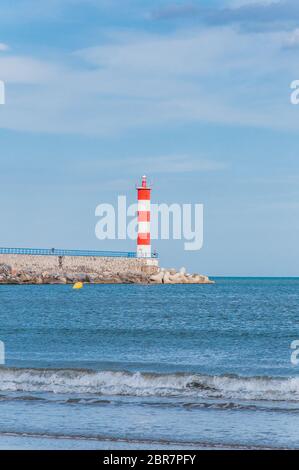 Leuchtturm von Port-La-Nouvelle in rot und weiß auf bewölktem Himmel in Occitanie, Frankreich Stockfoto