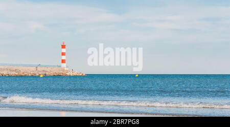 Leuchtturm von Port-La-Nouvelle in rot und weiß auf bewölktem Himmel in Occitanie, Frankreich Stockfoto