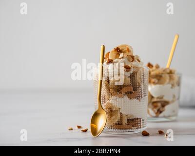 Kleindessert mit Banane, Mascarpone, Kekse und Mandeln Stockfoto
