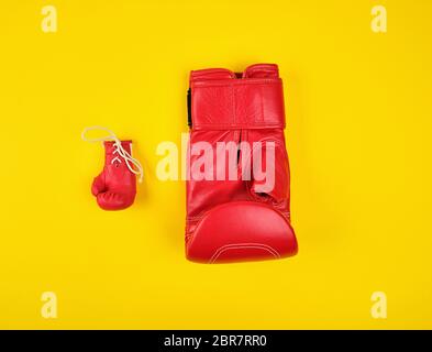 Zwei roten Boxhandschuhen auf gelbem Hintergrund, Konzept der Unterschied Stockfoto